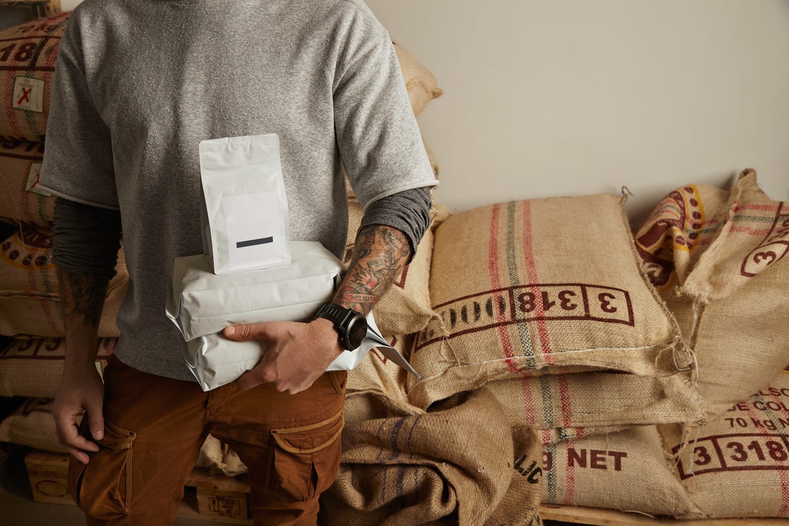 Barista segurando pacotes de grãos de café recém-torrados prontos para entrega